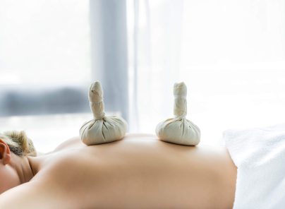 Kräuterstempelmassage auf dem Rücken einer liegenden Person im Gesundheitszentrum Radstadt.