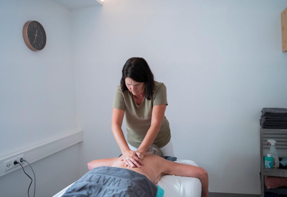 Physiotherapeutin behandelt Patientin auf Behandlungstisch im Gesundheitszentrum Radstadt.