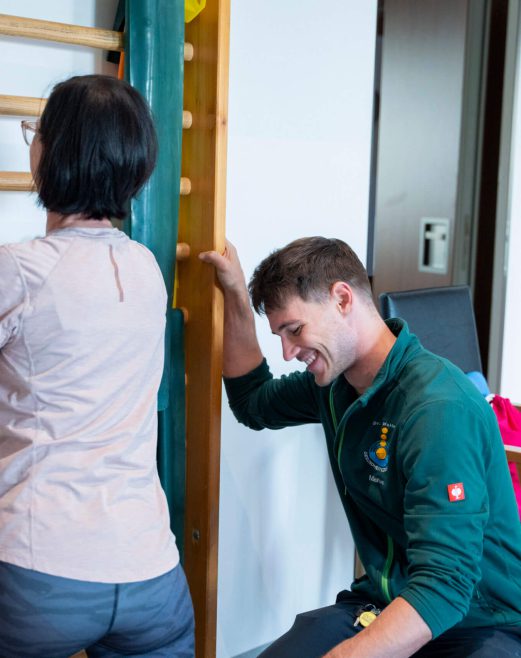 Physiotherapeut arbeitet mit Patientin an einer Trainingshilfe im Gesundheitszentrum Radstadt.