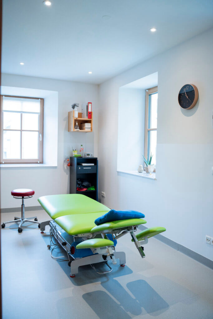 Behandlungsraum im Gesundheitszentrum Radstadt mit Therapie-Hochbett und Stuhl.