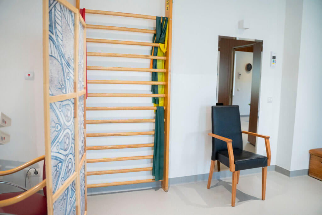 Therapieraum im Gesundheitszentrum Radstadt mit Trainingsgerät und Stuhl.