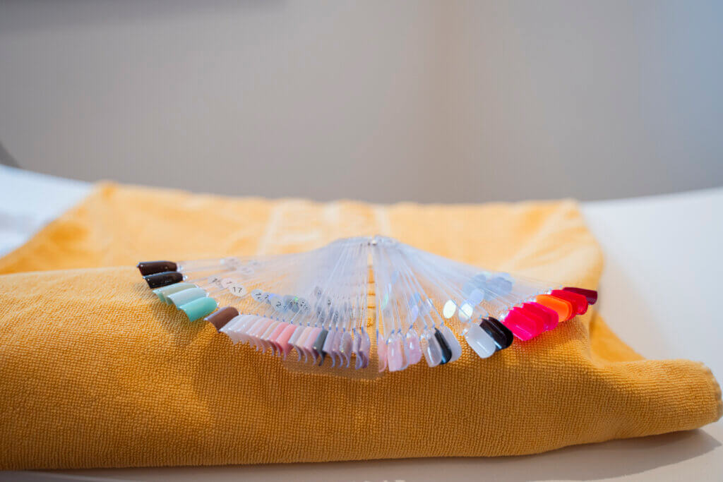 Farbauswahl für Fingernägel auf einem gelben Handtuch im Gesundheitszentrum Radstadt.