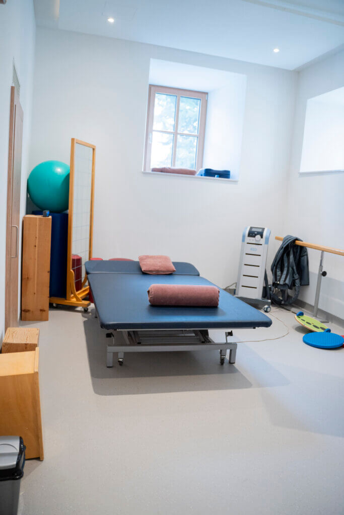 Therapieraum im Gesundheitszentrum Radstadt mit Behandlungsliege und Fitnessgeräten.